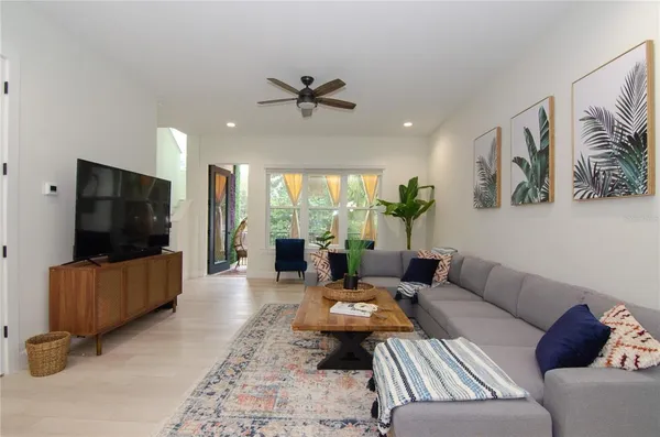 a dining room with furniture a chandelier and wooden floor