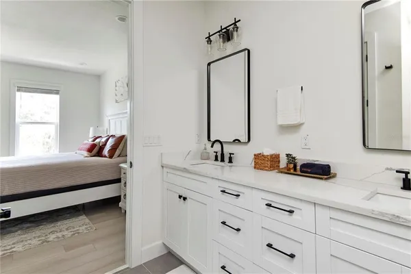 a bathroom with a double vanity sink toilet mirror and shower