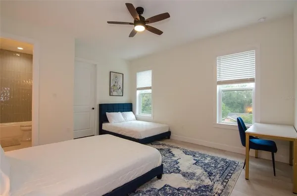 a bathroom with a granite countertop bathtub shower sink vanity and toilet