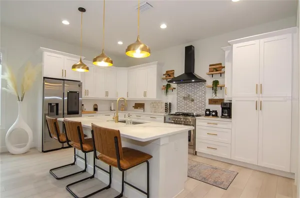 a kitchen with stainless steel appliances a stove a sink and a refrigerator
