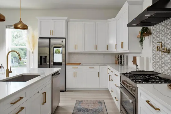a kitchen with stainless steel appliances kitchen island granite countertop a table and chairs in it