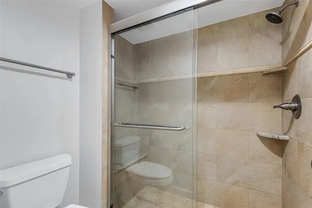 a bathroom with a toilet and a shower