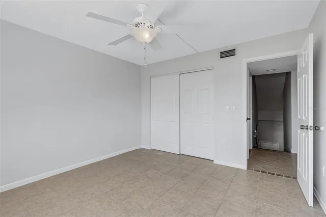 an empty room with a ceiling fan and a fan