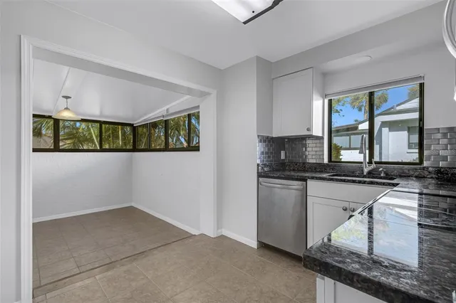 a view of a kitchen with a sink a refrigerator and cabinets