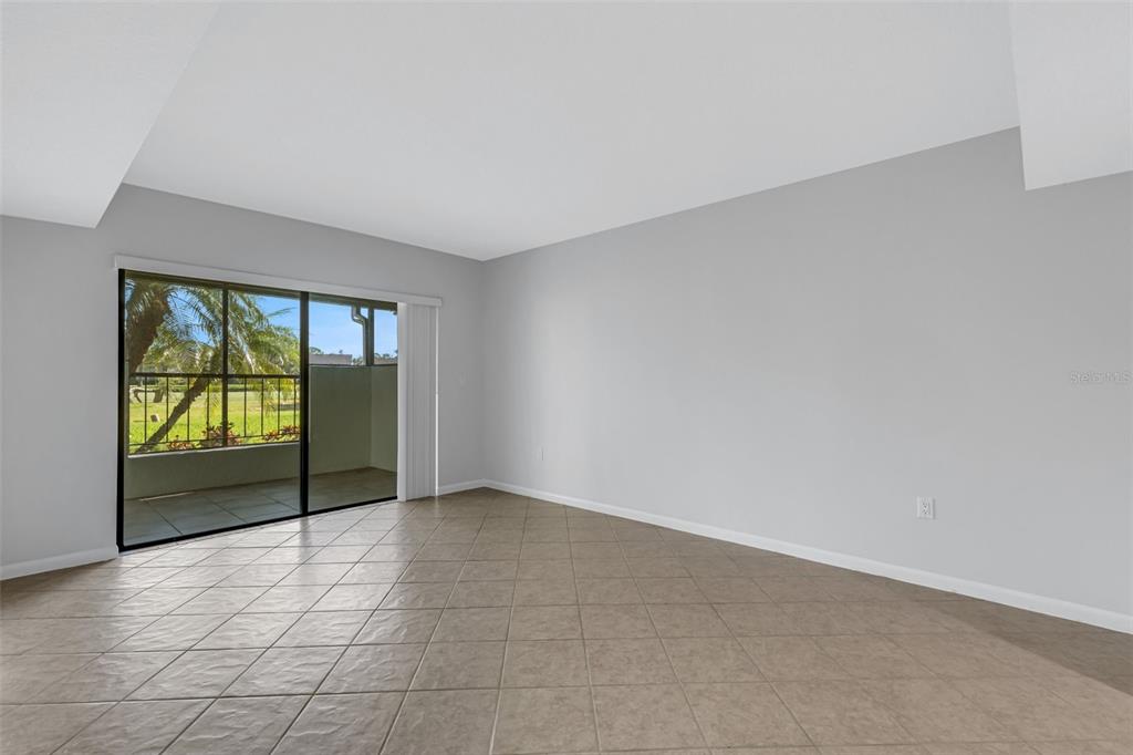 3119 Heatherwood Lane Sarasota, FL 34235 - Photo 6 of 47 an empty room with floor to ceiling window and an entryway