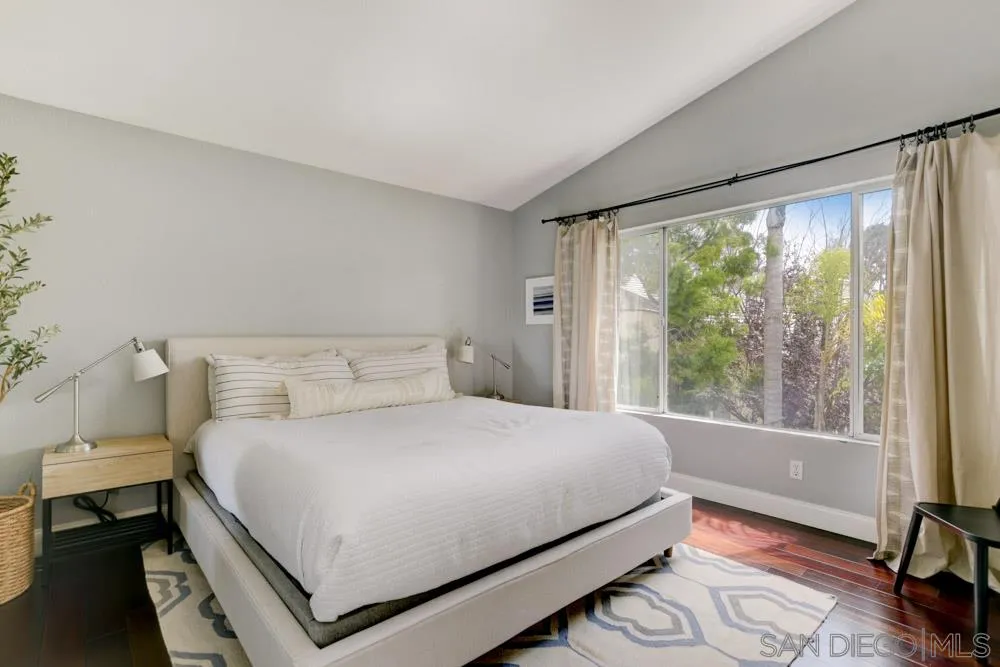 7730 Corte Marin Carlsbad, CA 92009 - Photo 14 of 26 a bedroom with a large bed and a large window