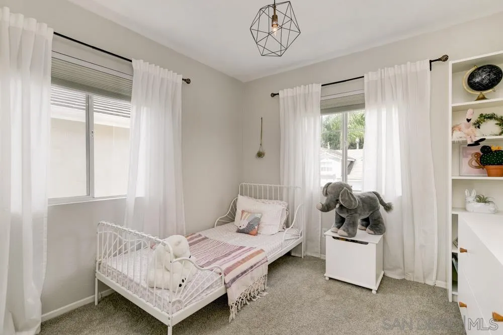 7730 Corte Marin Carlsbad, CA 92009 - Photo 18 of 26 a bedroom with furniture and a window