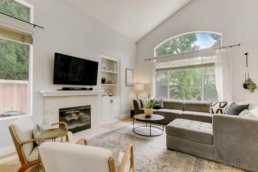 7730 Corte Marin Carlsbad, CA 92009 - Photo 4 of 26 a living room with furniture a fireplace and a flat screen tv