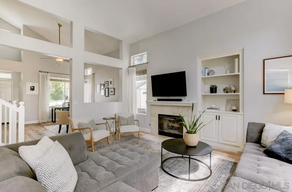 7730 Corte Marin Carlsbad, CA 92009 - Photo 9 of 26 a living room with furniture a flat screen tv and a fireplace