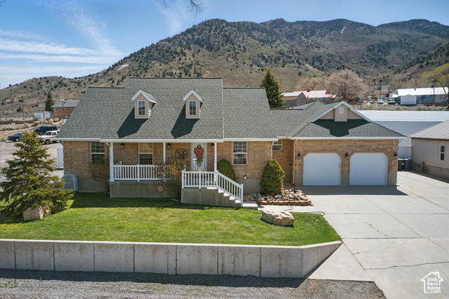 151 South Haulage Road Eureka, UT 84628 - Photo 2 of 36 Cape cod house featuring roof with shingles, a mountain view, a front lawn, and covered porch