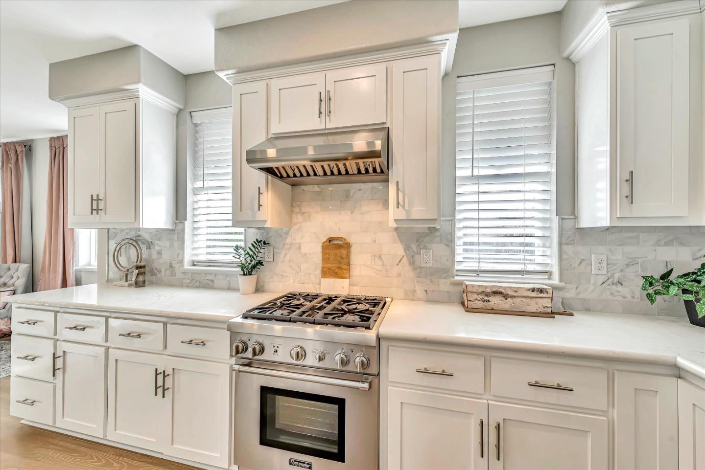 1512 Bond Street Milpitas, CA 95035 - Photo 11 of 49 a kitchen with white cabinets and a stove