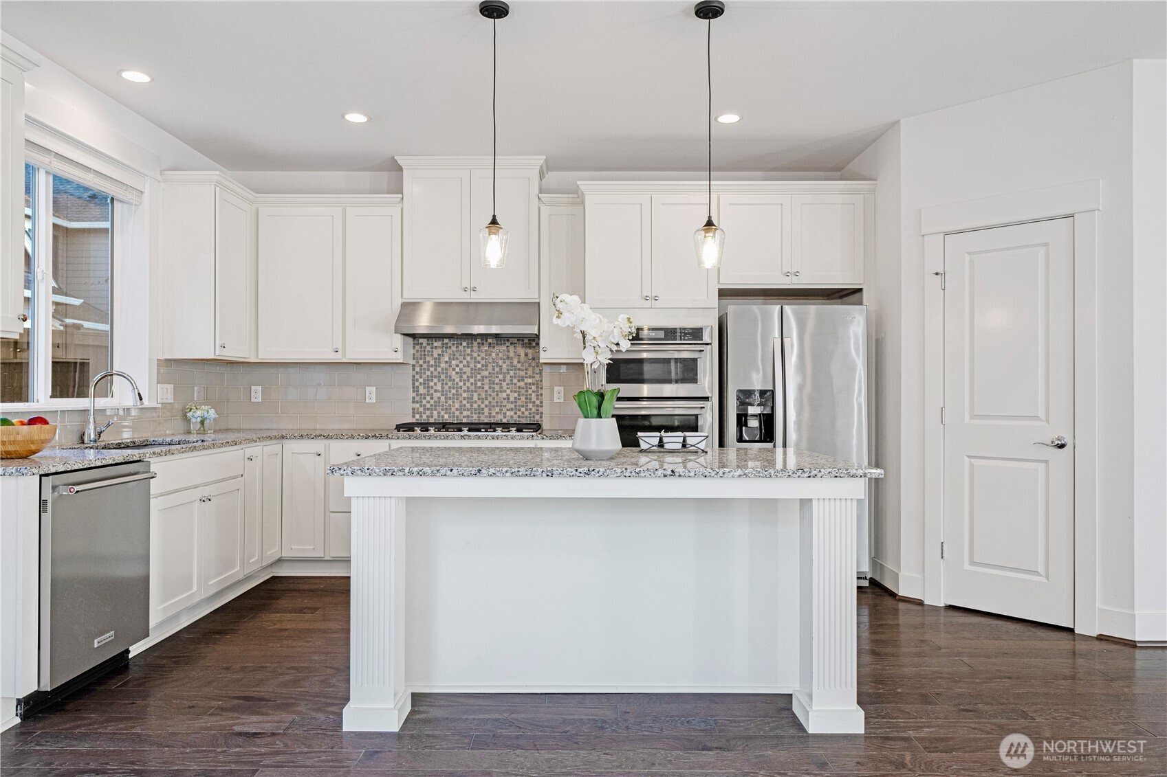 18717 43rd Drive Southeast Bothell, WA 98012 - Photo 9 of 26 a kitchen with stainless steel appliances granite countertop a sink a stove a refrigerator and island with wooden floor