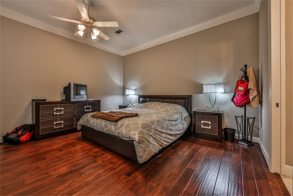 1005 Memorial Village Drive Houston, TX 77024 - Photo 19 of 32 a bedroom with a bed and wooden floor
