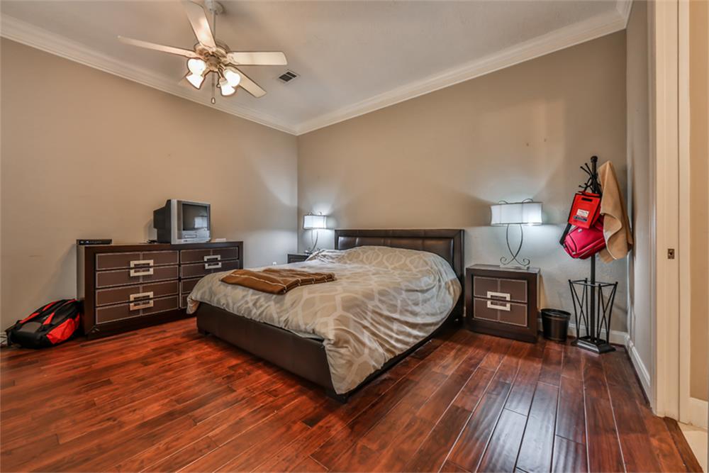 1005 Memorial Village Drive Houston, TX 77024 - Photo 20 of 32 a bedroom with a bed and wooden floor
