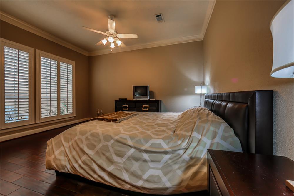 1005 Memorial Village Drive Houston, TX 77024 - Photo 21 of 32 a bedroom with a bed and wooden floor