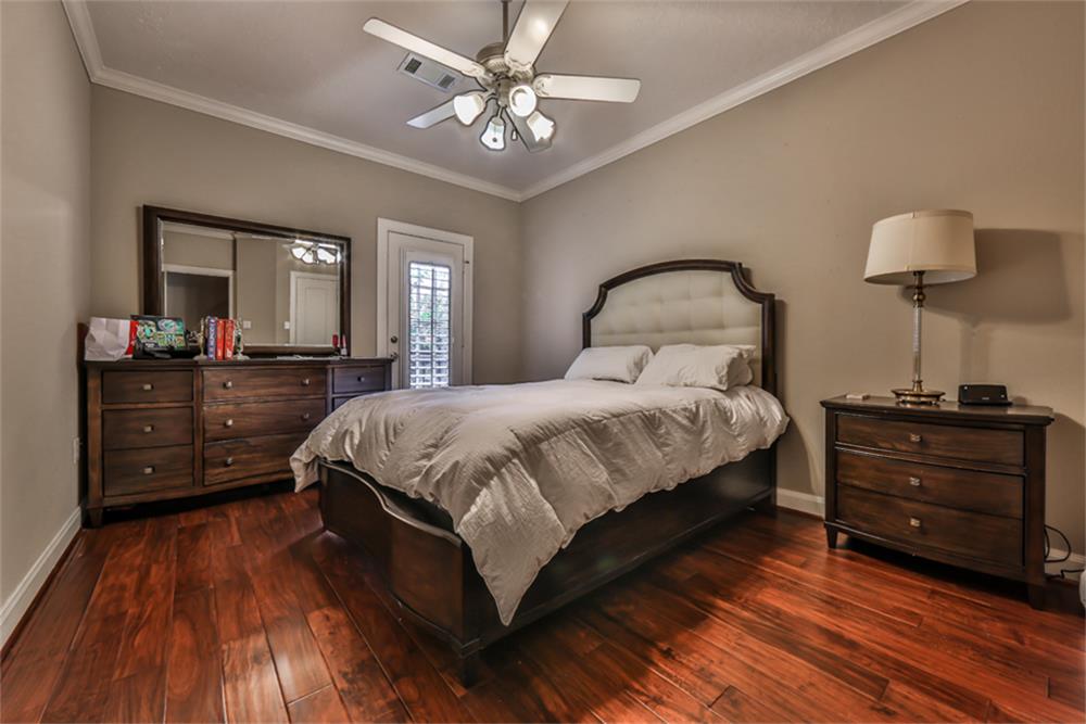 1005 Memorial Village Drive Houston, TX 77024 - Photo 23 of 32 a spacious bedroom with a bed and a dresser with wooden floor