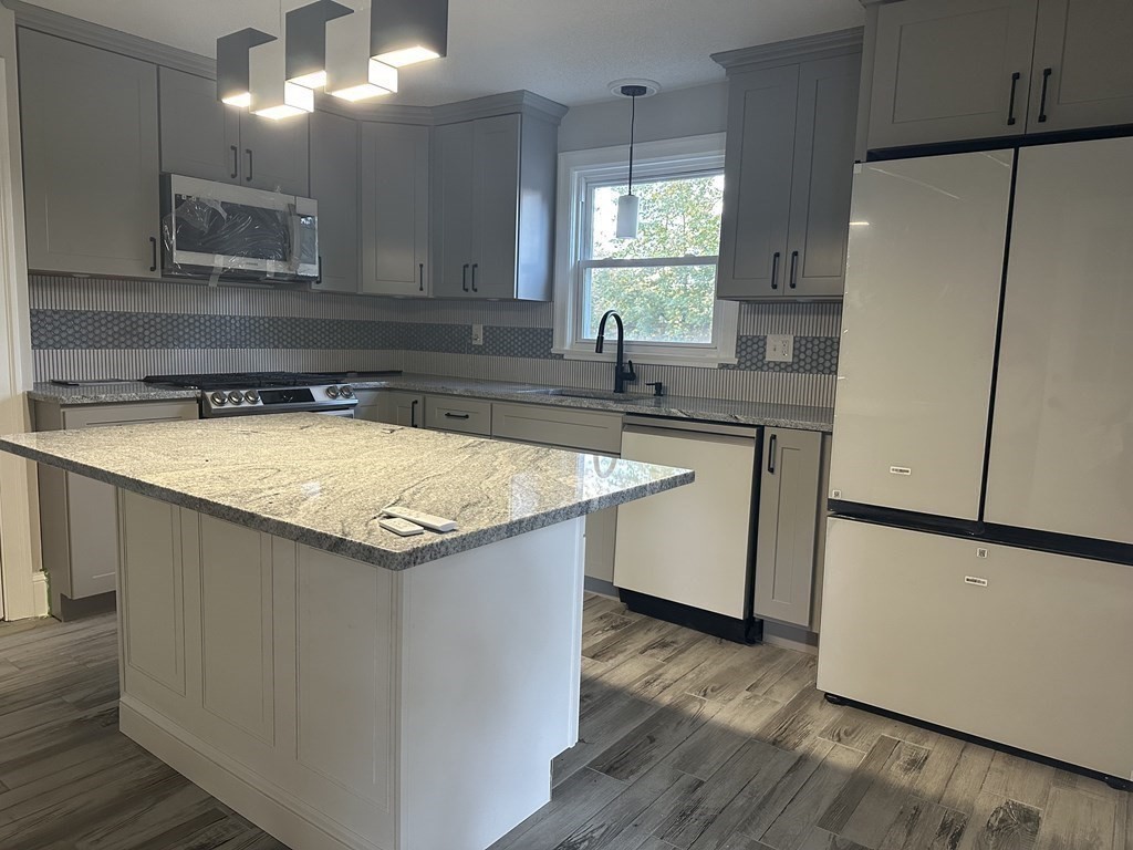 144 Stony Hill Road Wilbraham, MA 01095 - Photo 5 of 15 a kitchen with a sink a refrigerator a counter top space and two windows