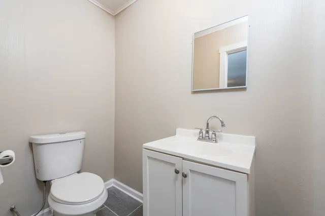a bathroom with a toilet a sink and mirror
