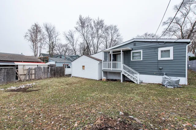 a white house that has a tree in front of it