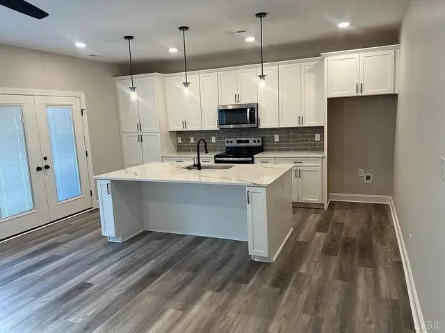 a white kitchen with a sink a microwave and cabinets