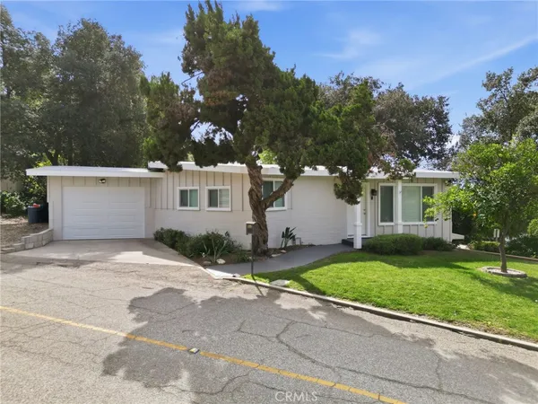 front view of a house with a yard and trees