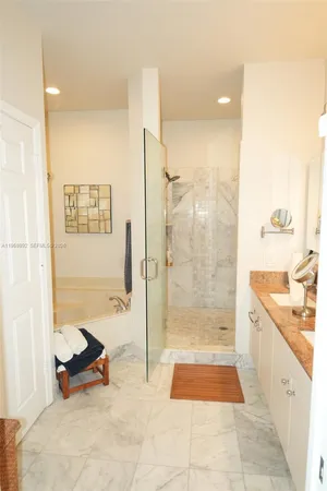 a bathroom with a granite countertop shower a mirror and a sink