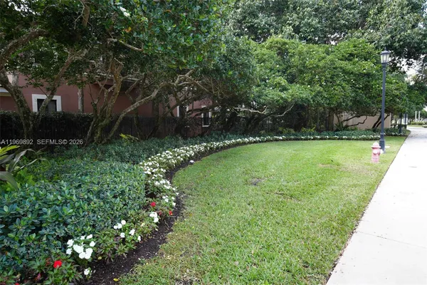 a view of a swimming pool with a yard and large trees