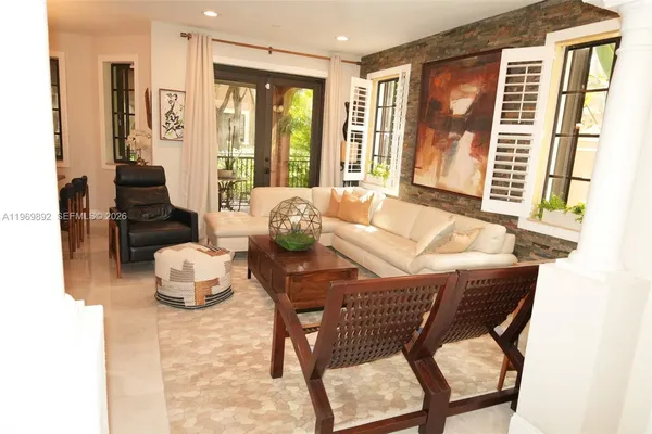 a living room with furniture and floor to ceiling windows