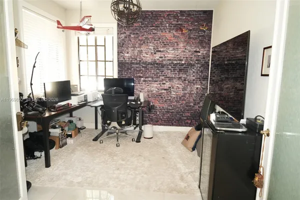 a view of a workspace with furniture and a window