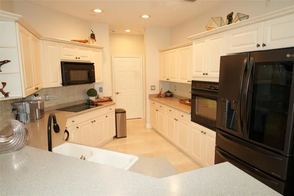 a kitchen with granite countertop a refrigerator stove and sink