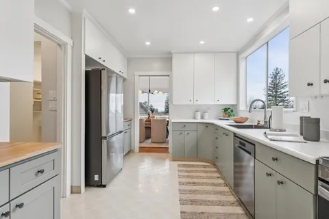 a bedroom with a bed a painting on the wall and a potted plant