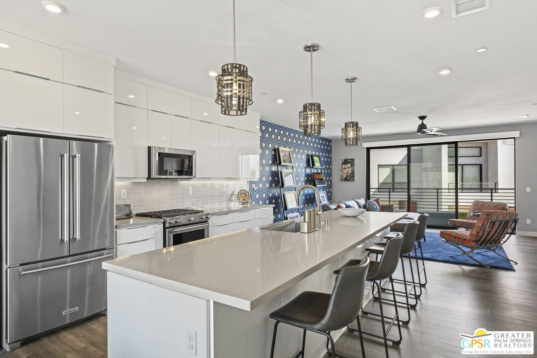 467 Huddle Spgs Way Palm Springs, CA 92264 - Photo 15 of 48 a open kitchen with stainless steel appliances granite countertop a stove a refrigerator a oven a sink a dining table and chairs with wooden floor