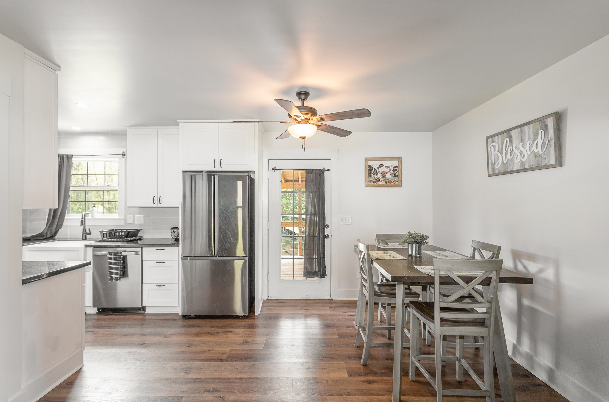 7953 Spot Light Road Lyles, TN 37098 - Photo 8 of 19 a kitchen with stainless steel appliances kitchen island granite countertop a refrigerator a stove a dining table and chairs with wooden floor