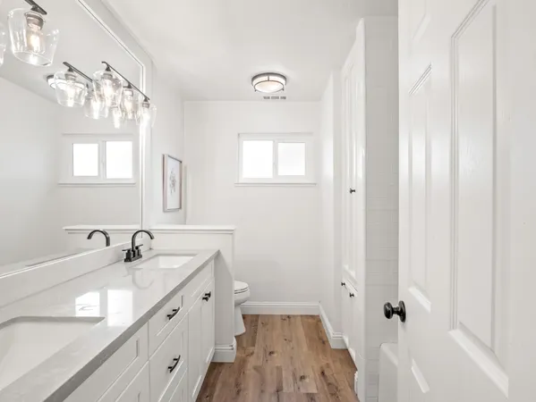 a bathroom with double vanity sink a mirror and a shower