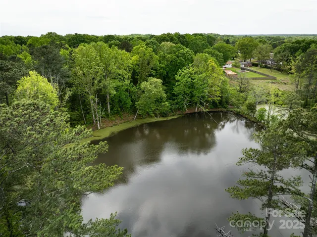 an aerial view of residential houses with outdoor space and trees