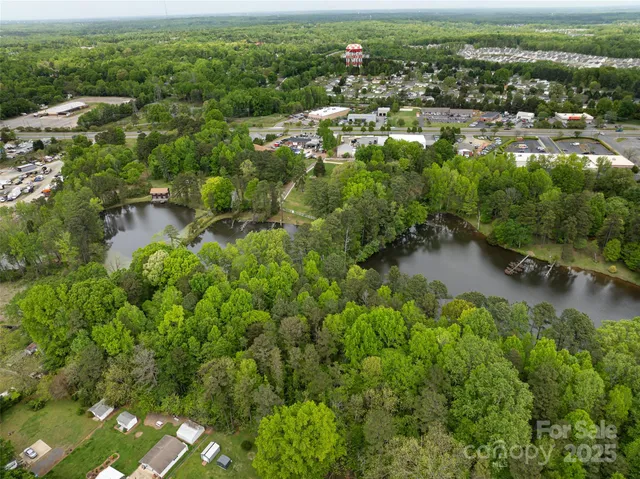 an aerial view of residential houses with outdoor space and trees