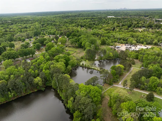 an aerial view of residential houses with outdoor space and trees