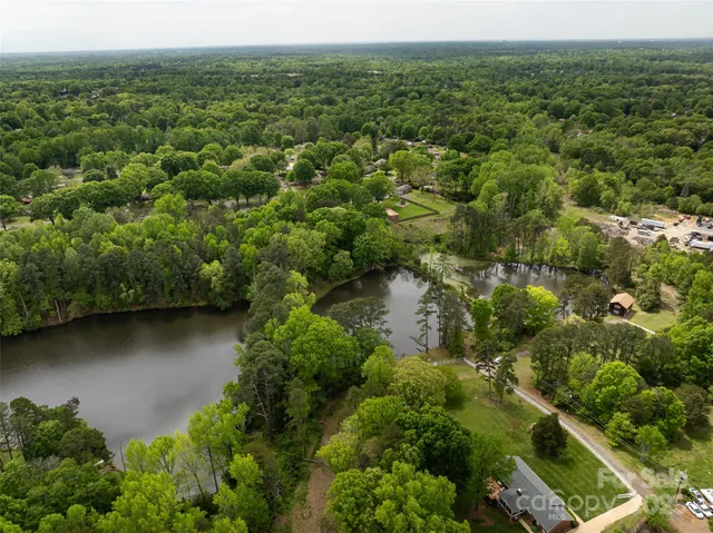 an aerial view of residential houses with outdoor space and trees