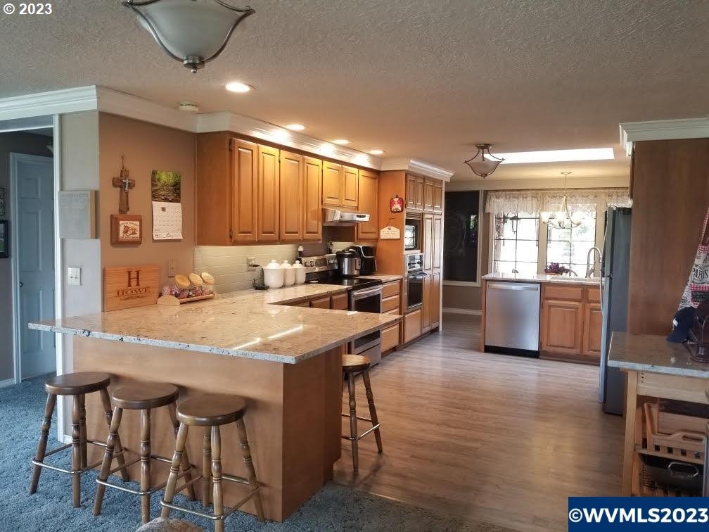 1320 North Fir Villa Road Dallas, OR 97338 - Photo 8 of 31 a kitchen with stainless steel appliances granite countertop counter space a sink and a refrigerator