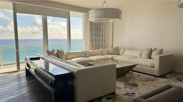 a living room with furniture and a chandelier