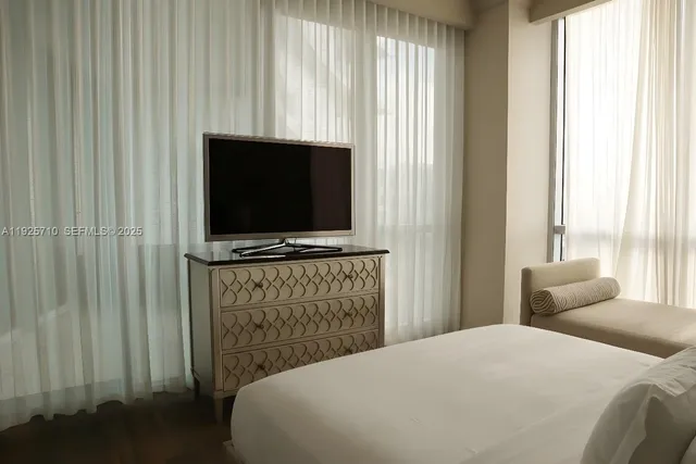 a bedroom with a bed and a flat screen tv