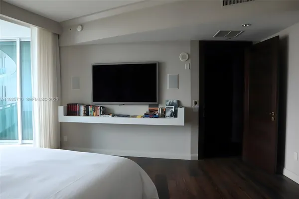 a bedroom with a bed and a view of kitchen