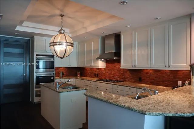 a kitchen with granite countertop a sink stainless steel appliances and cabinets