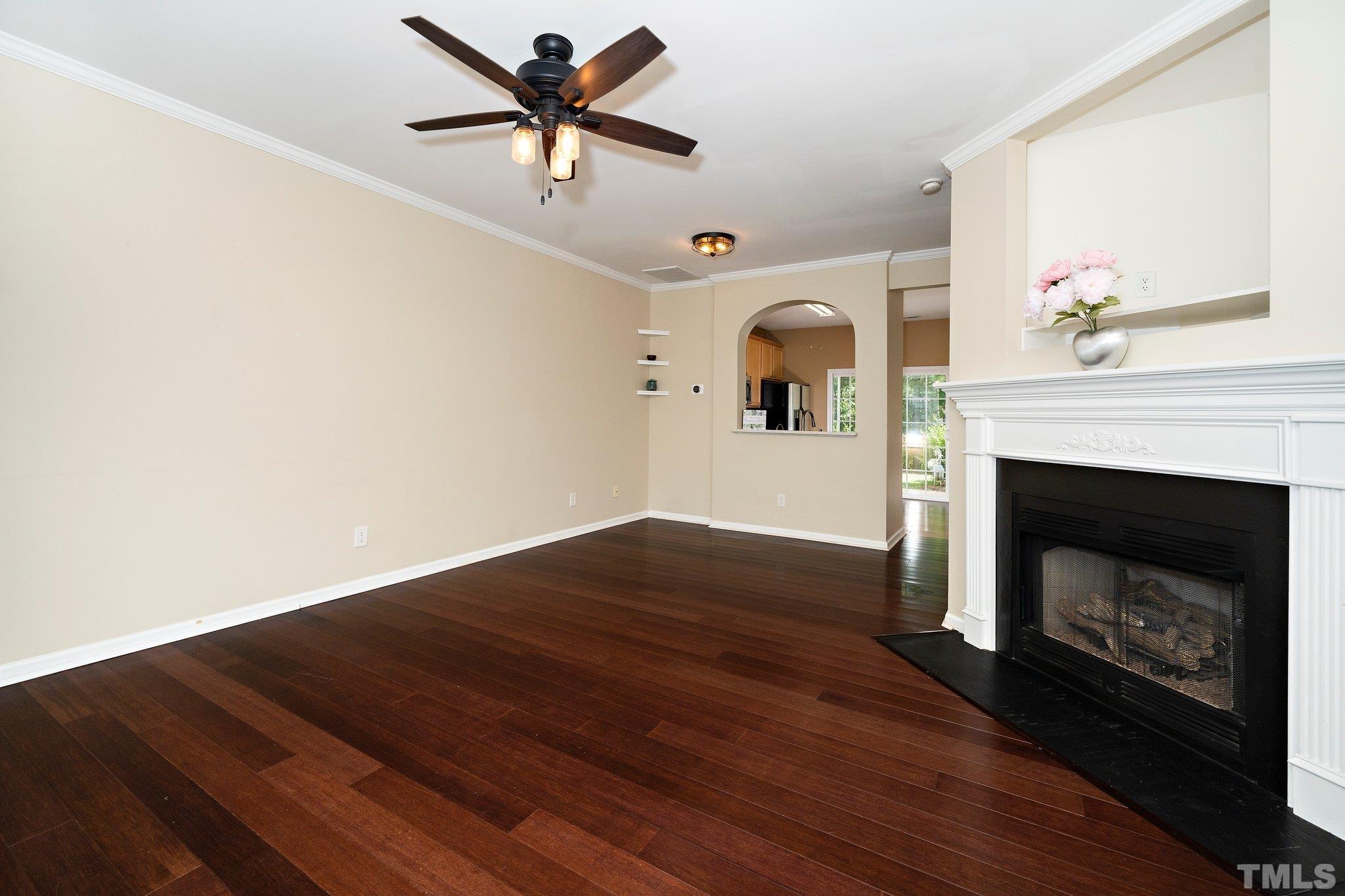 4114 Brenmar Lane Durham, NC 27713 - Photo 3 of 13 a view of a livingroom with a fireplace a ceiling fan and kitchen floor
