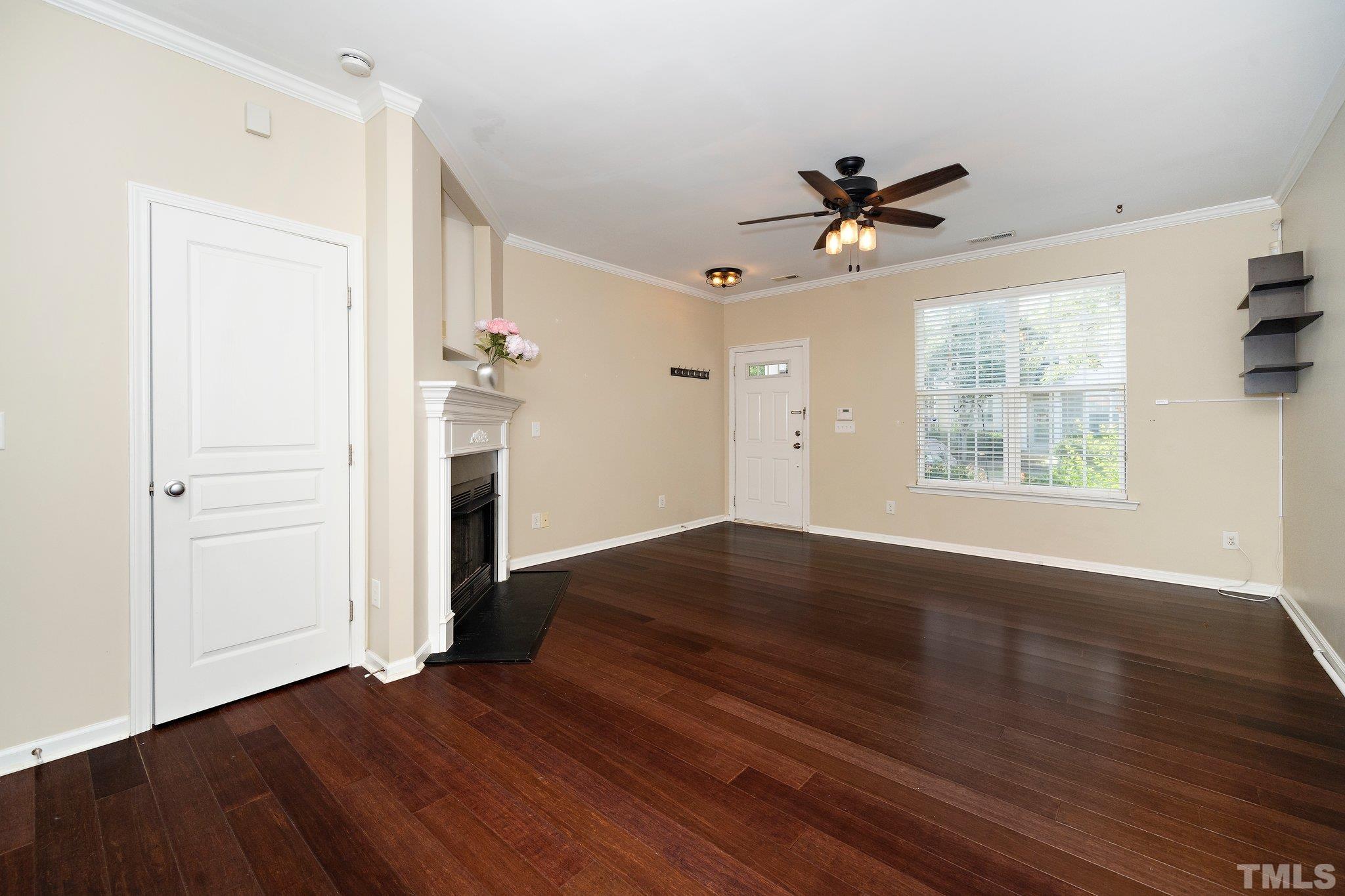 4114 Brenmar Lane Durham, NC 27713 - Photo 4 of 13 an empty room with wooden floor ceiling fan and windows