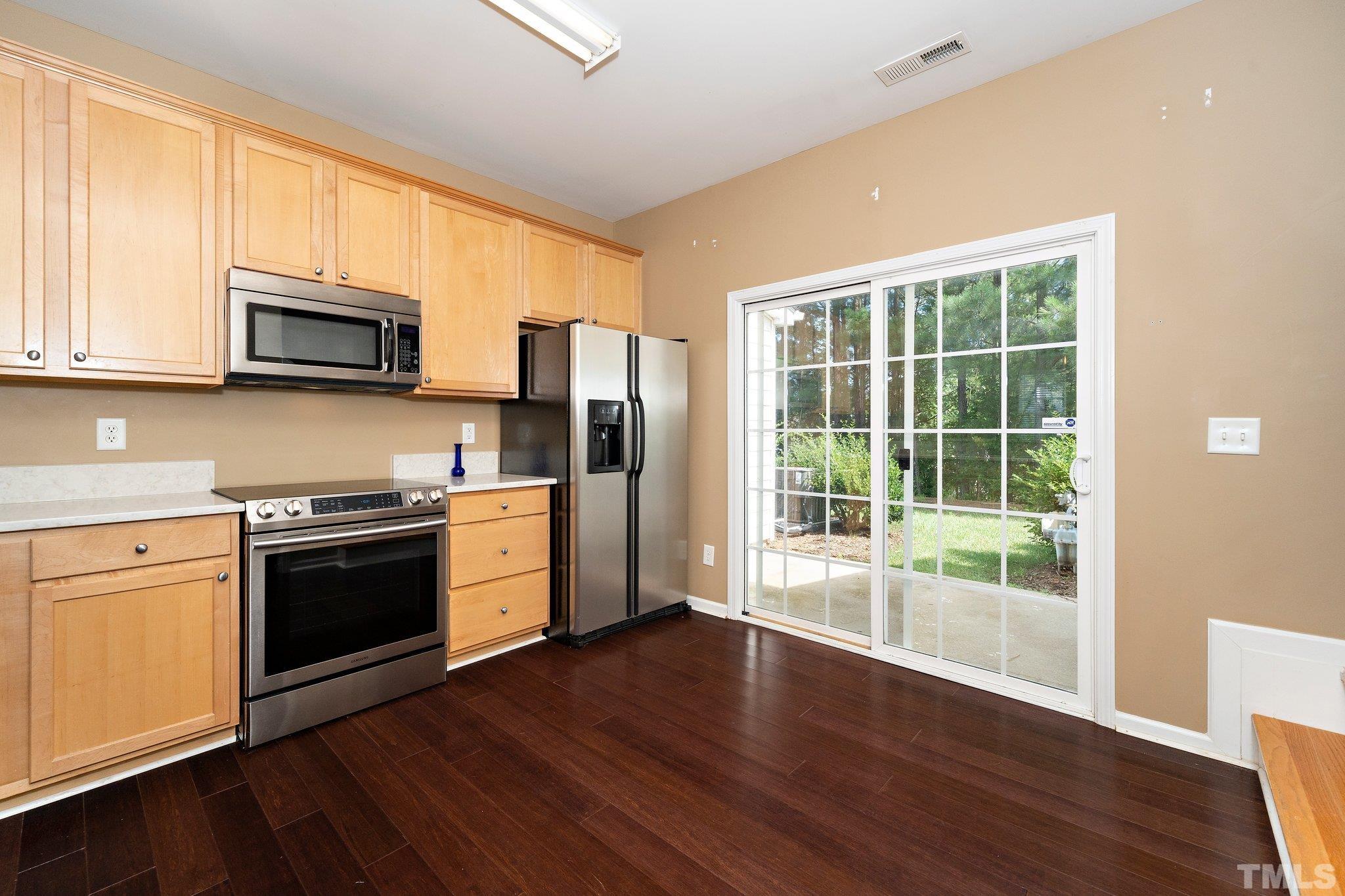 4114 Brenmar Lane Durham, NC 27713 - Photo 7 of 13 a kitchen with stainless steel appliances wooden cabinets and a stove top oven