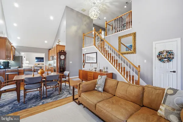 a living room with furniture kitchen view and a wooden floor