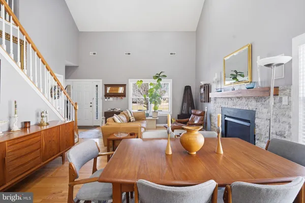 a view of a dining room with furniture a fireplace and wooden floor