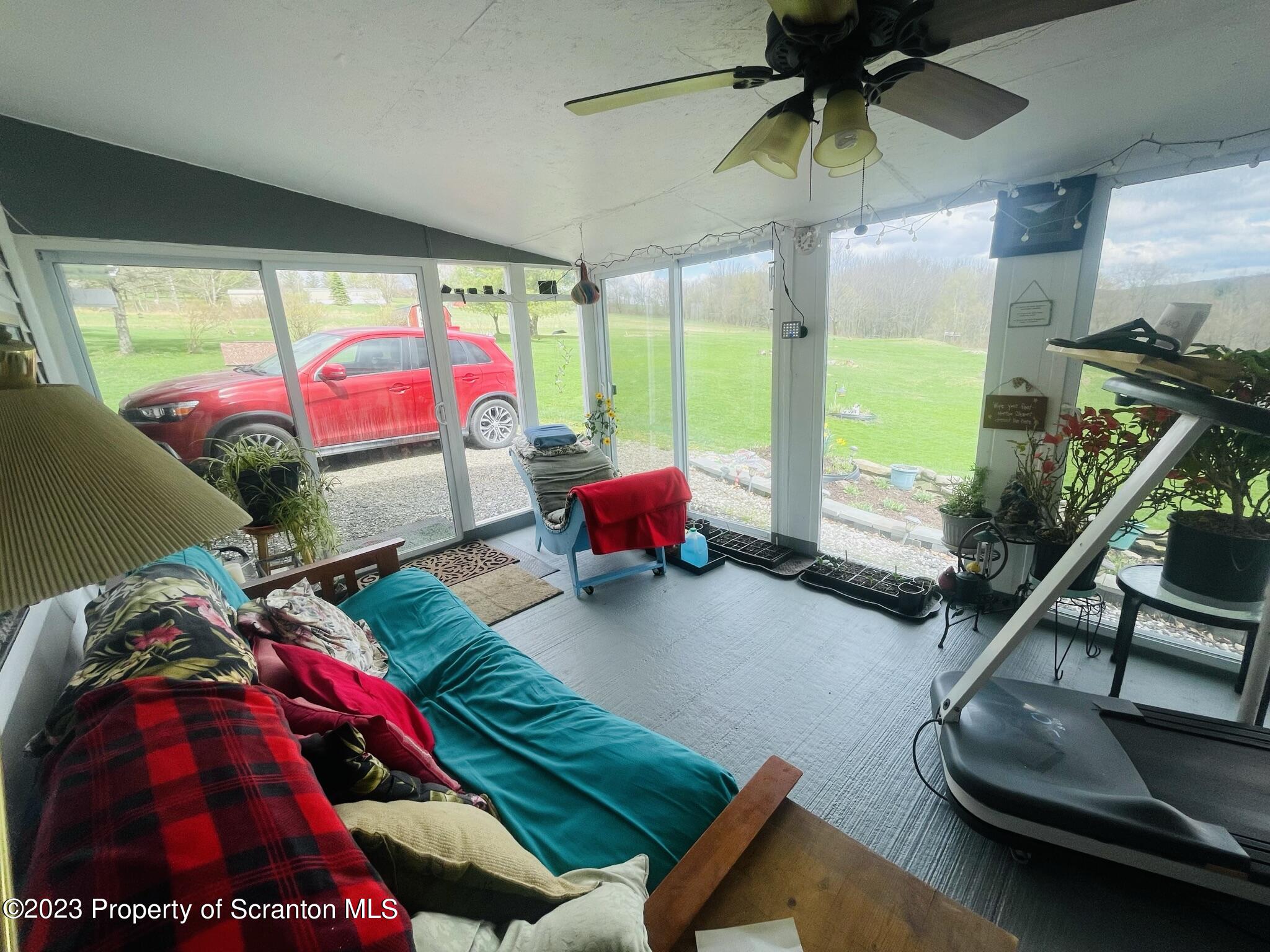 176 Stack Road Thompson, PA 18465 - Photo 16 of 53 a living room with a floor to ceiling window and a table