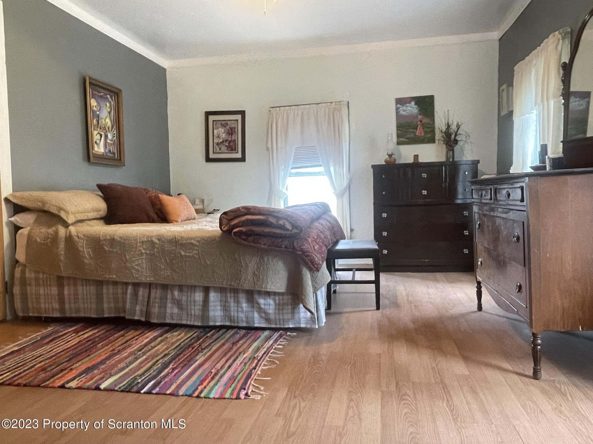 176 Stack Road Thompson, PA 18465 - Photo 20 of 53 a bedroom with a bed and paintings on the wall